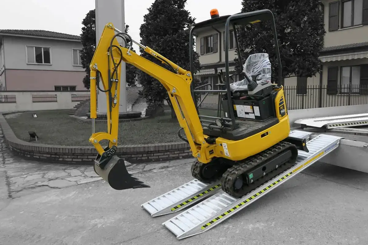 mini escavatore per movimento terra che scende da un furgone sulle rampe di carico in alluminio lotus alutech